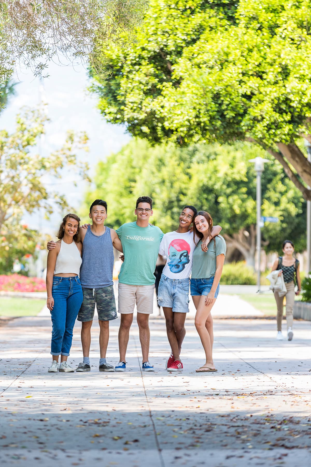 Five UCSB students outdoors with arms wrapped around each other's shoulders