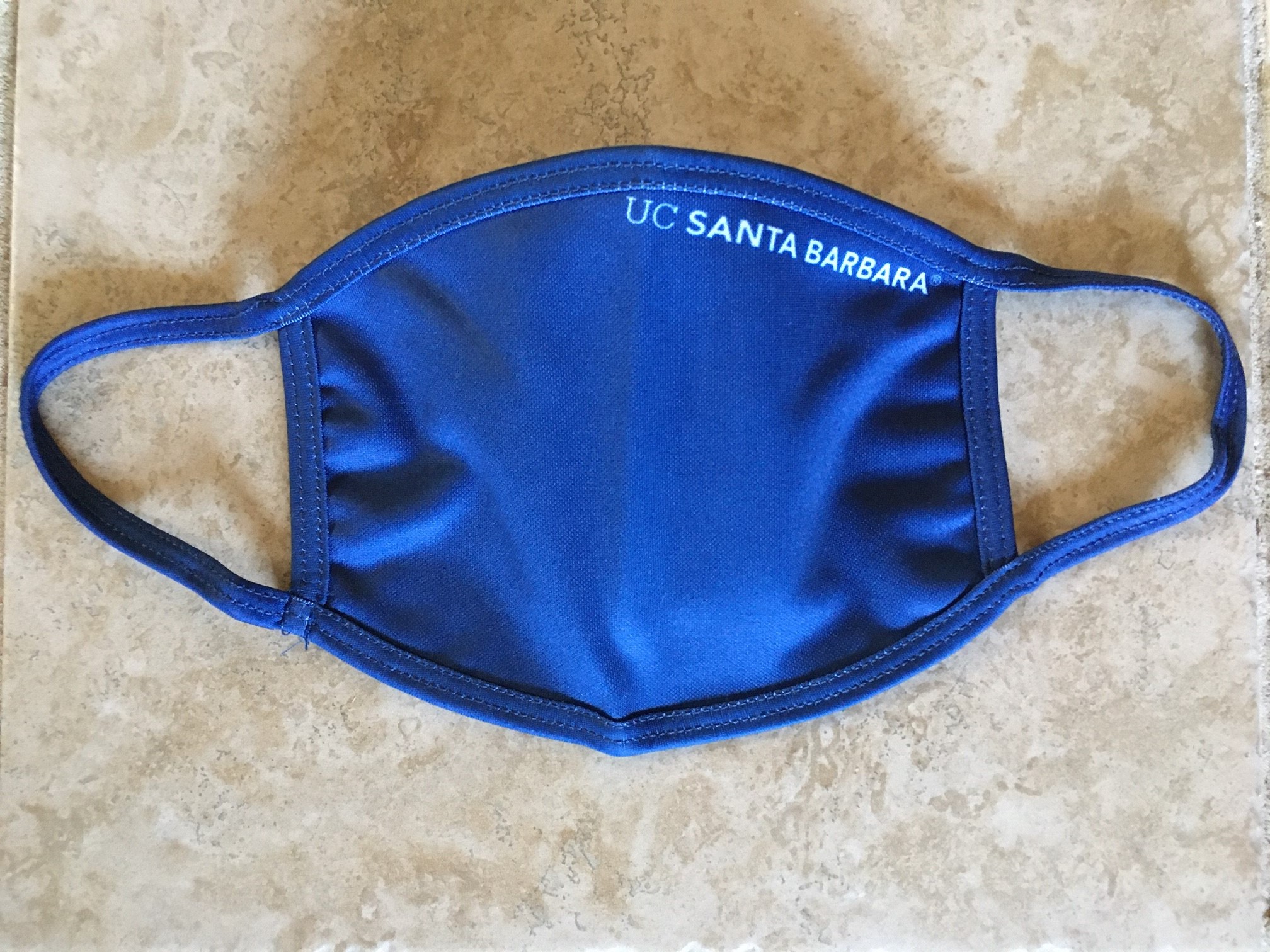 A blue facemask with the text "UC Santa Barbara" on it